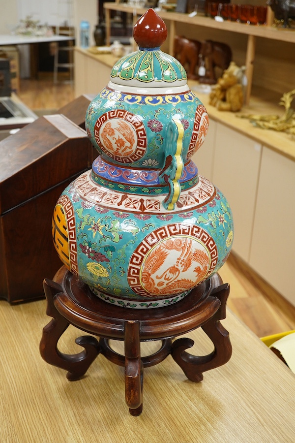 A Chinese double-gourd vase and cover, on associated hardwood stand, total height 65cm. Condition - fair to good